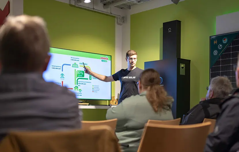 Photovoltaik Infoabend - Ein Solarteur erklärt an einem Whiteboard vor Zuschauern die auf Stühlen sitzen