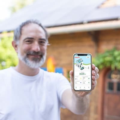 Ein Mann hält ein Smartphone mit enerixControl in die Kamera