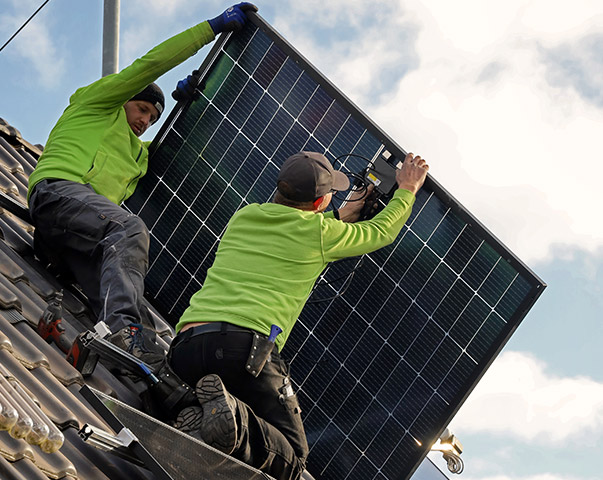 Solarteure die ein Solarmodul auf einem Hausdach befestigen