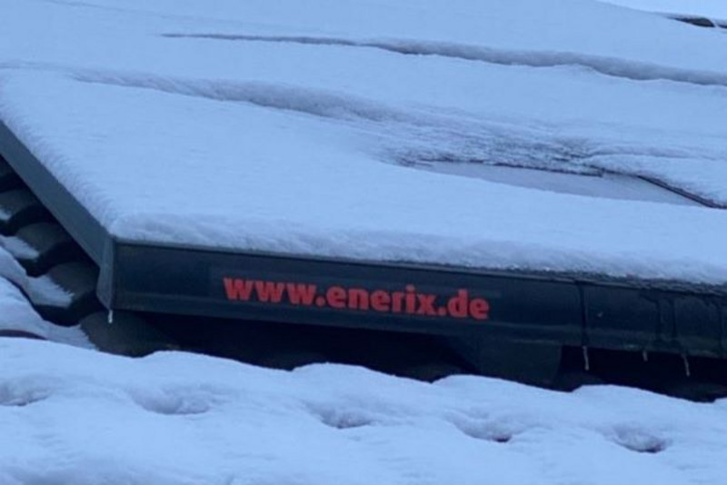 Photovoltaikanlage mit Schnee bedeckt. Ein enerix Logo ist zu sehen.