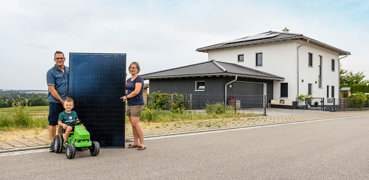 a family posing in front of a house with a pv-system