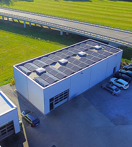 Eine aufgeständerte Photovoltaikanlage auf dem Dach eines Lagerhauses eines Unternehmens