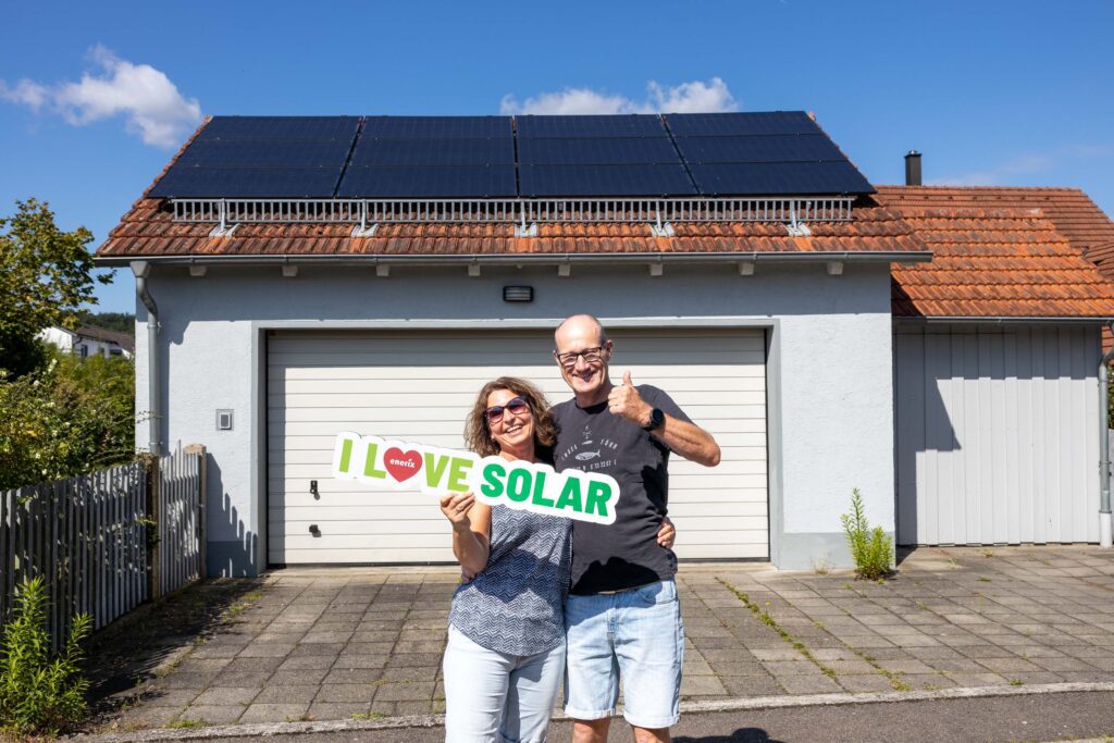 Eine Familie vor ihrer Solaranlage. Sie freut sich über die neue PV Anlage, die steuerfrei ist. 