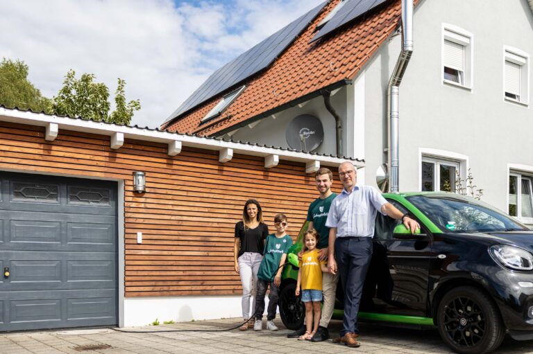 Familie Meyer vor ihrem Haus, dass mit Photovoltaik Förderung finanziert wurde.