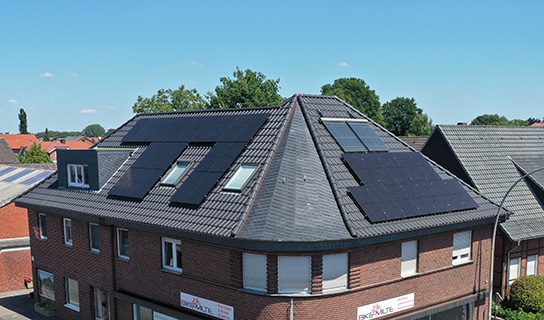 Eine Photovoltaikanlage auf dem Dach eines Mehrfamilienhauses. Die Bewohner beziehen Mieterstrom.