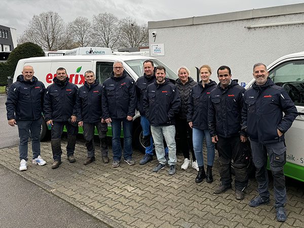 Ein Team von Photovoltaik Monteuren und Experten von enerix Stuttgart stehen vor Fahrzeugen